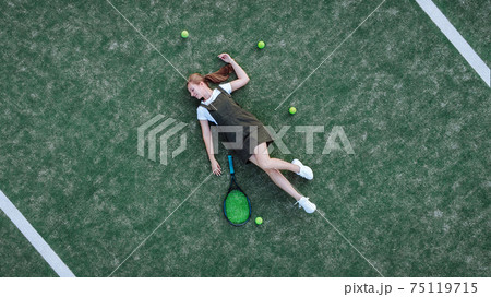 Beautiful girl lies on a tennis court Beautiful girl lies on a tennis court 75119715