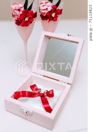 Wedding rings in a pink casket, with decorated champagne glasses Wedding rings in a pink casket, with decorated champagne glasses 75119825