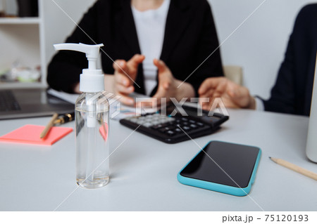 Close-up of workspace with antiseptic gel to disinfect hands in an office. Preventive measures during the period of epidemic and social exclusion Close-up of workspace with antiseptic gel to disinfect hands in an office. Preventive measures during the period of epidemic and social exclusion 75120193