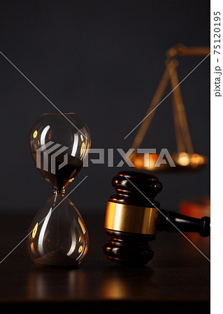 Judge's gavel, scales of justice and hourglass on wooden table. Law and justice concept 75120195