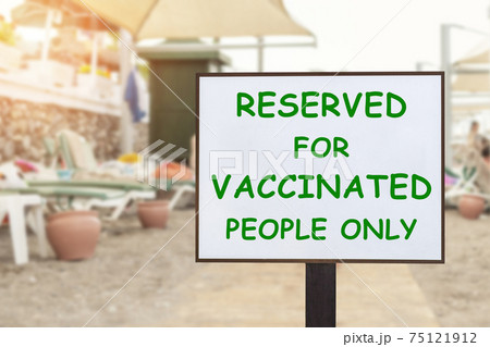 Text plate RESERVED FOR VACCINATED PEOPLE ONLY at luxury hotel sea beach resort area empty loungers on summer day. New normal travel and vacation concept. Covid-19 pandemic restriction and limit Text plate RESERVED FOR VACCINATED PEOPLE ONLY at luxury hotel sea beach resort area empty loungers on summer day. New normal travel and vacation concept. Covid-19 pandemic restriction and limit 75121912
