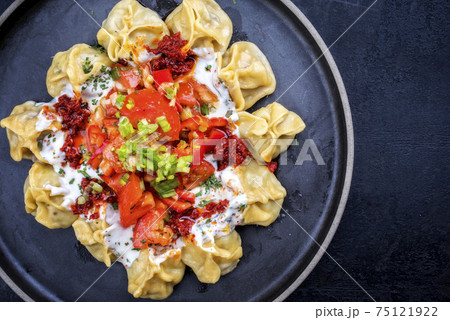 Traditional Turk manti steamed with mincemeat and paprika tomato salad Traditional Turk manti steamed with mincemeat and paprika tomato salad 75121922