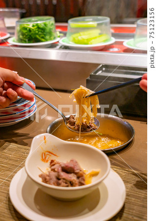 Human using chopsticks and eating enoki mushroom hotpot Human using chopsticks and eating enoki mushroom hotpot 75123156