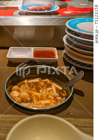 Spicy enoki mushroom soup in hotpot conveyor belt restaurant 75123158