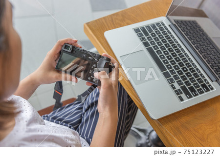 Female using mirrorless camera when preview images 75123227