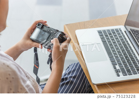 Woman hands pressing button on mirrorless camera 75123228