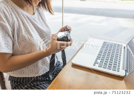 Female using mirrorless camera when preview images Female using mirrorless camera when preview images 75123232