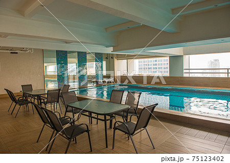 Empty swimming pool area at modern condominium building 75123402