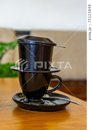 Vertical photo of Vietnamese black colored metallic coffee dripping filter  75123849