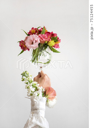 Wine glass full of fresh Spring flowers in female Wine glass full of fresh Spring flowers in female 75124455
