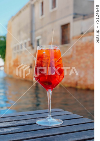 Glass of refreshing Aperol Spritz cocktail served on the deck bar in Venice. 75124648
