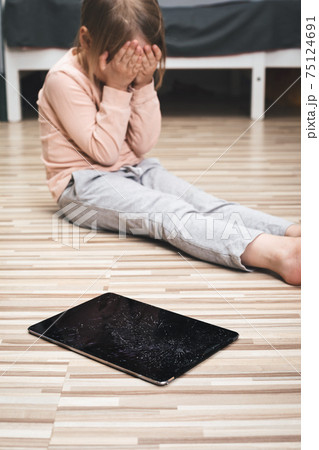 Upset child crying over broken tablet computer Upset child crying over broken tablet computer 75124691