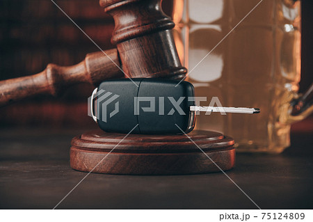 Glass of beer, car keys close-up and judge gavel on a wooden table. Alcohol and car accidents concept 75124809