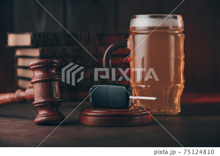 Glass of beer, car keys and wooden gavel. Alcohol and car accidents concept Glass of beer, car keys and wooden gavel. Alcohol and car accidents concept 75124810