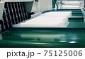 Factory worker wrapping many plastic cups 75125006
