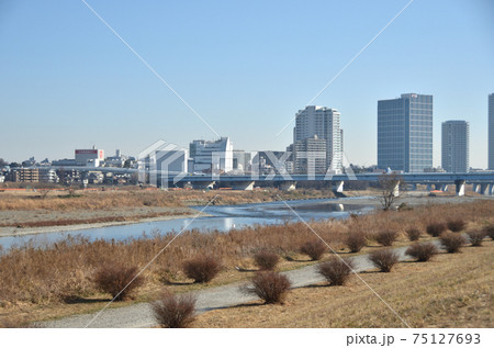冬の多摩川から見た二子玉川駅のビル群の景色・都会の川 75127693