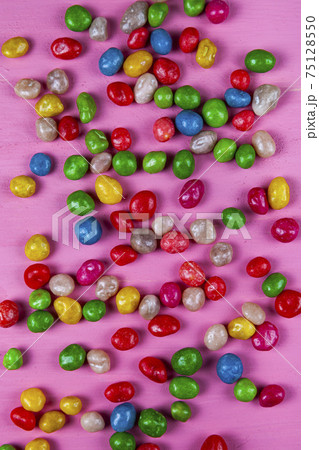 Multicolored candies on a pink  background. 75128550
