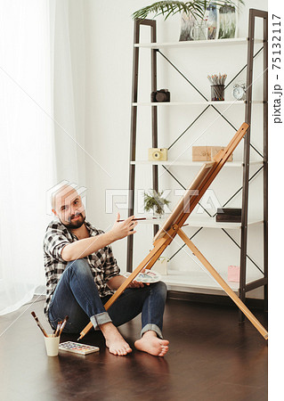 Artist painting with watercolor in home studio 75132117