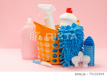 Bottles of dishwashing liquid and sponges with a basket on pink background. Bottles of dishwashing liquid and sponges with a basket on pink background. 75132934