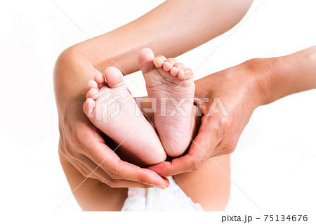 小さくてかわいい赤ちゃんの足の裏とママの手の写真素材