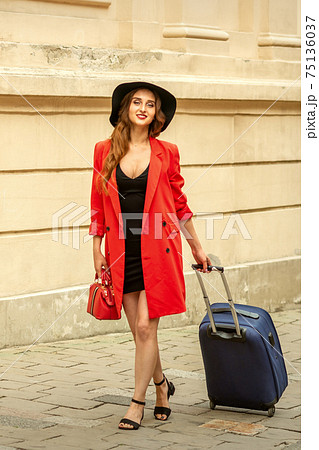Woman is walking with suitcase Woman is walking with suitcase 75136037