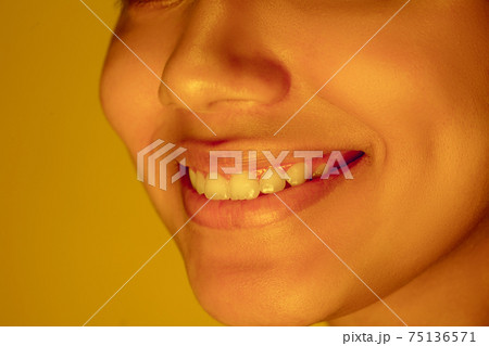 Beautiful african-american woman portrait isolated on yellow studio background in neon light, monochrome Beautiful african-american woman portrait isolated on yellow studio background in neon light, monochrome 75136571