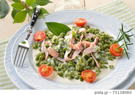 South Tyrolean spinach spaetzle with parmesan cream sauce, strips of ham and fried tomatoes South Tyrolean spinach spaetzle with parmesan cream sauce, strips of ham and fried tomatoes 75138060