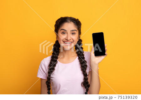 Indian woman showing blank cellphone screen for mockup 75139320
