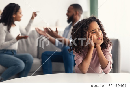 Sad black girl with her fighting parents in the background Sad black girl with her fighting parents in the background 75139461