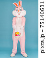 Easter bunny or rabbit or hare with basket of colored eggs, having fun, dancing, celebrates Happy easter. Easter rabbit isolated on blue background 75140631