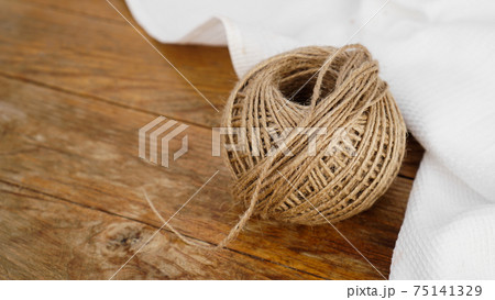 Skeins of jute rope on wooden table flat lay background with copy space. 75141329