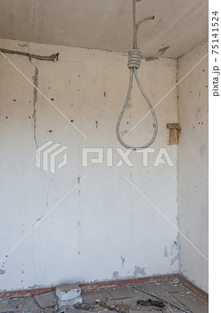 Deadly loop hanging from the ceiling in abandoned apartment. Concept of suicide, despair Deadly loop hanging from the ceiling in abandoned apartment. Concept of suicide, despair 75141524