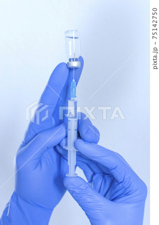 Doctor hands holding a vaccine bottle and syringe,beginning of worldwide mass vaccination for coronavirus COVID-19,influenza or flu,world immunization concept. Selective focus Doctor hands holding a vaccine bottle and syringe,beginning of worldwide mass vaccination for coronavirus COVID-19,influenza or flu,world immunization concept. Selective focus 75142750