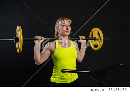 Girl on a fitness trampoline on a black background in a yellow t-shirt trampoline gym sport, equipment activity caucasian workout Fly white motion, athletic muscle instructor enjoy 75143179
