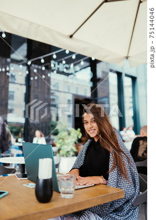 Portrait of female student using net-book while sitting in cafe Portrait of female student using net-book while sitting in cafe 75144046