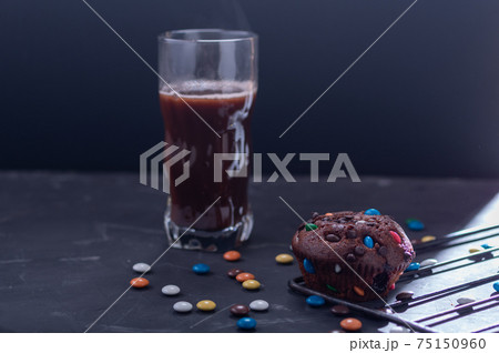 Chocolate muffin and cocoa in a glass. Snack with muffins and cocoa. 75150960