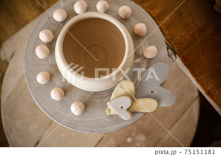 Clay pot on top of a potter's wheel Clay pot on top of a potter's wheel 75151181