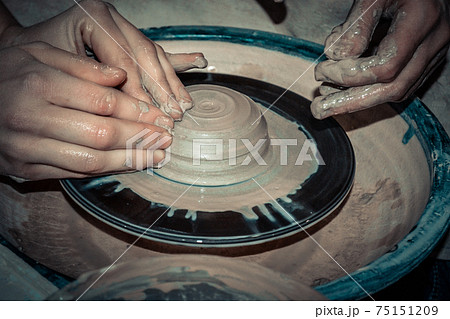 The potter molds a jug on the circle 75151209