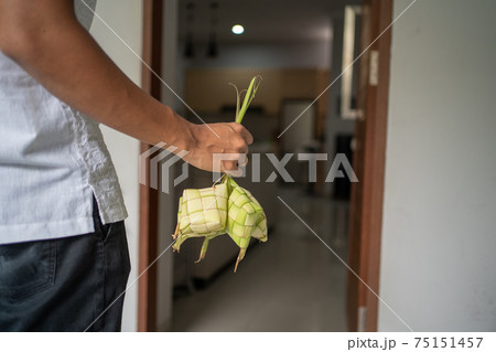 gesture of male hand carrying a ketupat home for eid mubarak gesture of male hand carrying a ketupat home for eid mubarak 75151457