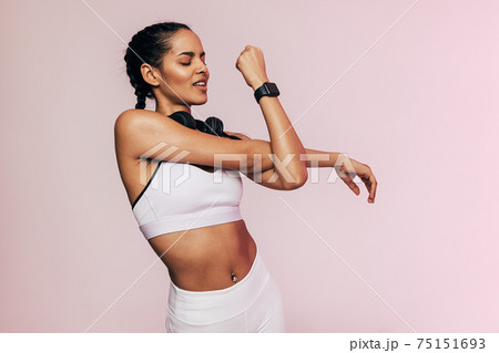 Portrait of a fitness woman stretching her arms in studio Portrait of a fitness woman stretching her arms in studio 75151693