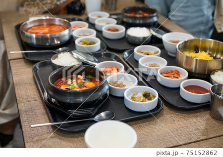 Various of Korean food with spicy soup, kimchi, noodles and vegetable pickle on tray Various of Korean food with spicy soup, kimchi, noodles and vegetable pickle on tray 75152862
