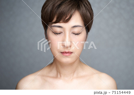 正面を向いて目をつぶる中年の日本人女性 75154449