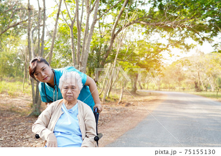 Doctor help and care Asian senior or elderly old lady woman patient sitting on wheelchair at park in nursing hospital ward 75155130
