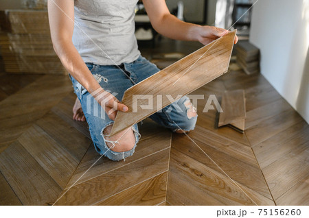 Man laying parquet flooring - closeup on male hands. worker joining parquet floor 75156260