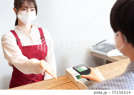 スマホ決済をするマスク着用の店員とお客 75156314