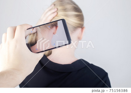 The woman shows his neck with a chip implanted which is read or scanned by a special device. Concept of chipping and implantation of electronic technologies. Cybernetics and the nanofuture. Cyberpunk The woman shows his neck with a chip implanted which is read or scanned by a special device. Concept of chipping and implantation of electronic technologies. Cybernetics and the nanofuture. Cyberpunk 75156386