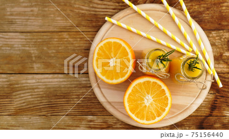 Orange juice in glass bottles. The juice is decorated with a sprig of rosemary Orange juice in glass bottles. The juice is decorated with a sprig of rosemary 75156440