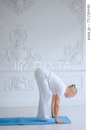 Man practicing advanced yoga against a white background Man practicing advanced yoga against a white background 75156446