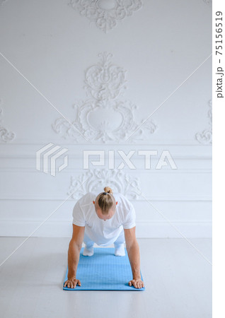Man practicing advanced yoga against a white background 75156519