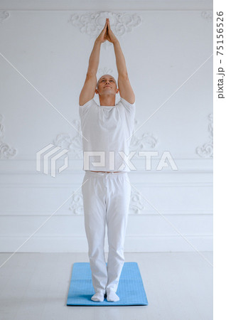 Man practicing advanced yoga against a white background 75156526